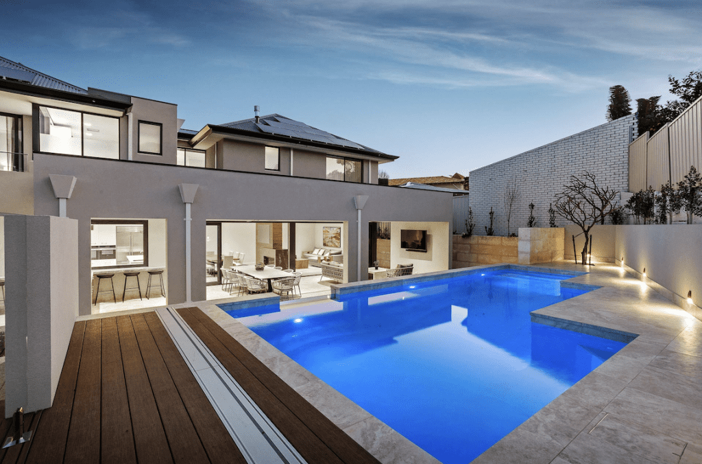 Exterior view of luxury home with large pool area showing us of composite wood decking around pool